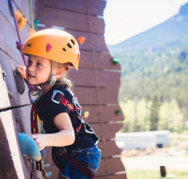 Little girl scaling a climbing wall