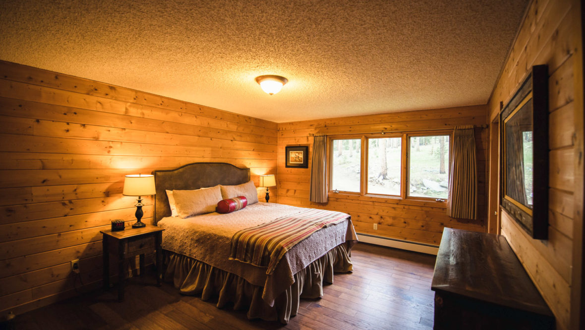 Chalet second large bedroom with a king size bed and large window.
