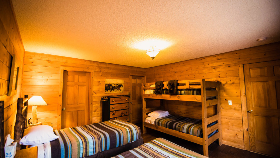 Third bedroom in the chalet cabin with two twin beds and a set of bunk beds.