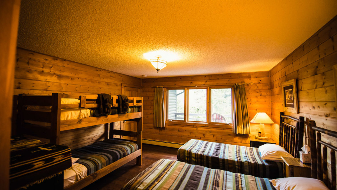 Third bedroom in the chalet cabin with two twin beds and a set of bunk beds.