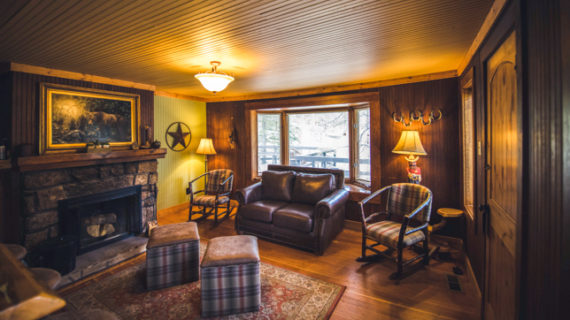Meeker cabin living room with coffee table and leather coach.
