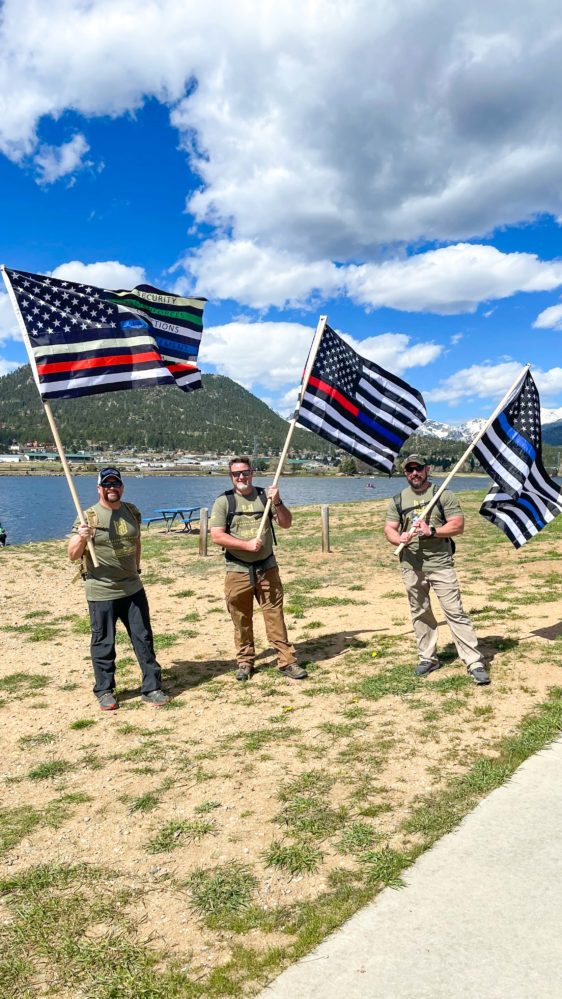 Three men holding three variations of the American flag