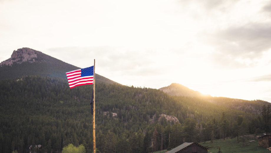 American flag and beautiful mountain landscape.