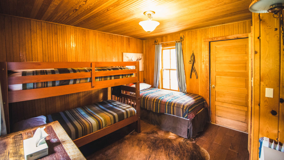 Trailhead cabin kids bedroom with a set of bunkbeds and one twin bed.