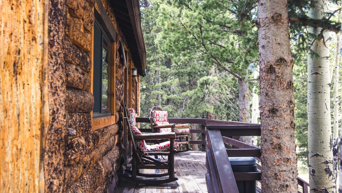 Aspen leaf cabin front porch with two deck chairs.
